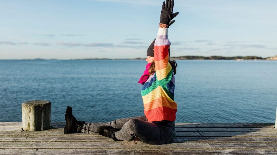 Yogalärare Isabel i randig tröja på brygga vid havet