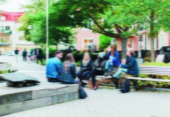 unga flickor och två vuxna sitter tillsammans på parkbänkar