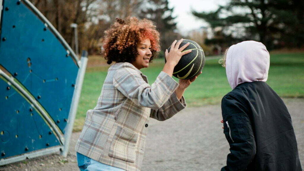 flicka och pojke kastar boll