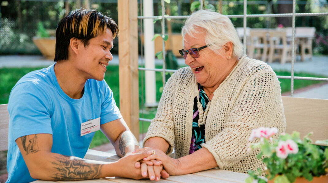 medarbetare och äldre kvinna sitter tillsammans