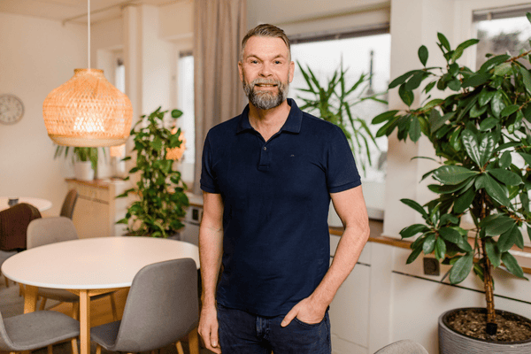 Kille i rum med lampa och växt