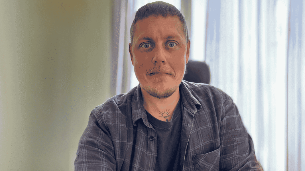 Man sitter vid skrivbord vid fönster
